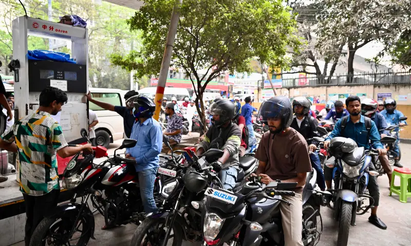 People refuel their motorbikes at a gas station in Dhaka on March 10, 2026. &mdash; AFP