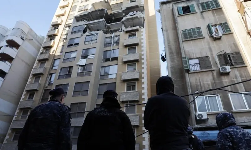 Emergency personnel stand near a damaged apartment building in the aftermath of an Israeli strike, in central Beirut, Lebanon, March 11, 2026. &mdash;Reuters