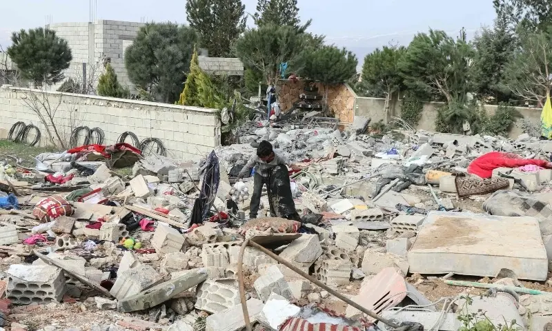 A young resident searches through debris at the site of an overnight Israeli airstrike in the village of Younine, in Lebanon&rsquo;s Bekaa Valley, on March 12, 2026. &mdash;AFP