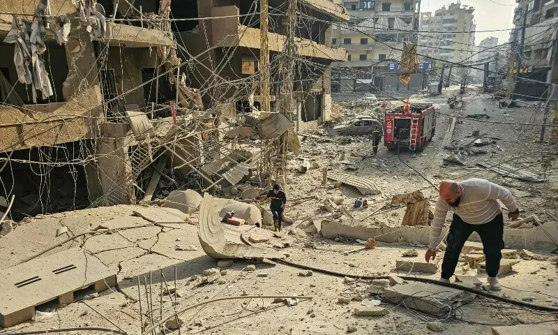A man stands on the rubble of a destroyed building as firefighters work at the site of overnight Israeli airstrikes in the Haret Hreik neighbourhood of Beirut&rsquo;s southern suburbs on March 12, 2026. &mdash;Reuters