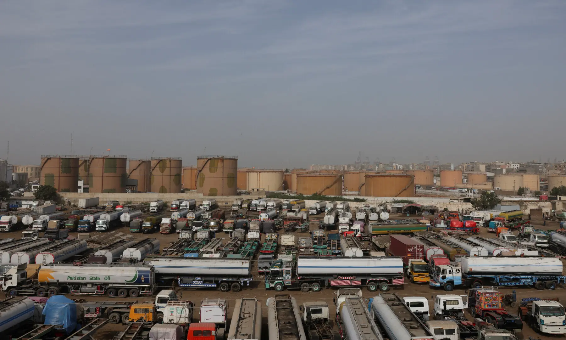 Oil tankers are parked in a compound with oil terminals in the background, amid the U.S.-Israeli conflict with Iran, in Karachi, on March 12, 2026. &mdash; Reuters