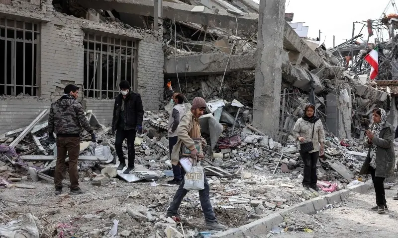 Iranians collect belongings from the rubble of a damaged residential building in Tehran on March 12. &mdash; AFP