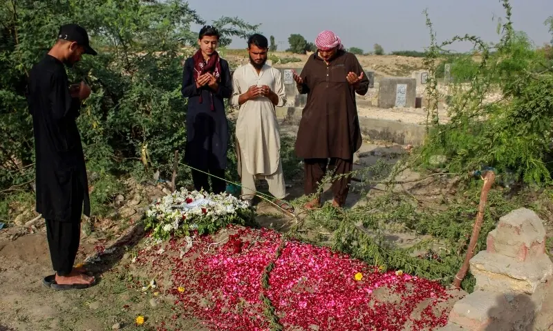 Relatives offer prayers on the grave of Pakistani national Muzaffar Ali, who was killed in Dubai amid the ongoing Middle East war, after his funeral in Jamshoro in Sindh on March 12. &mdash; AFP