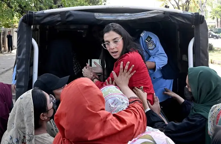 Plain clothes police personnel detain an Aurat March activist in Islamabad.—AFP/File Plain clothes police personnel detain an Aurat March activist in Islamabad.—AFP/File