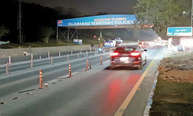 Vehicles pass through empty Faizabad checkpost. — Photo by Tanveer Shahzad Vehicles pass through empty Faizabad checkpost. — Photo by Tanveer Shahzad