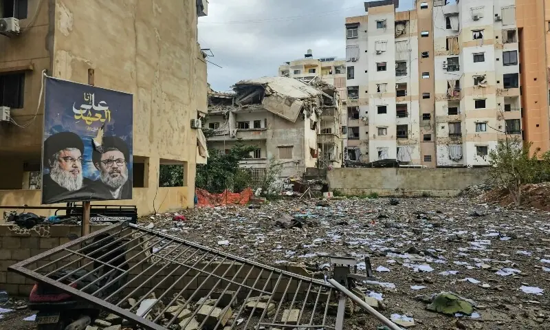 A photograph shows a banner bearing portraits the slain leaders of the Lebanese Shia movement Hezbollah, Hassan Nasrallah (L) and Hashem Safieddine, at the site of an overnight Israeli airstrike that targeted the Burj al-Barajneh neighbourhood in Beirut&rsquo;s southern suburbs, on March 14, 2026. &mdash;Reuters