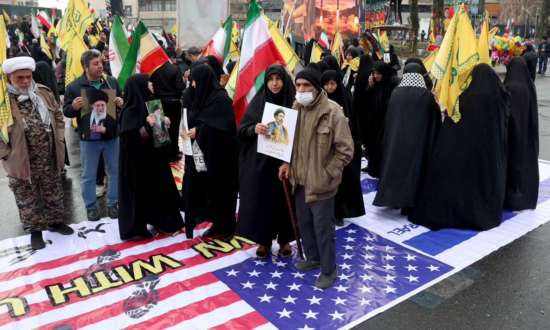 Iranian stand on a large US flag during the Al-Quds (Jerusalem) Day rally, a commemoration in support of the Palestinian people on the last Friday of the Islamic holy month of Ramadan, in Tehran on March 13, 2026. &mdash; AFP