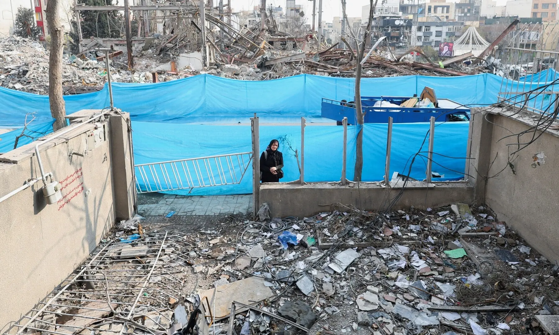 A woman looks at her house which was destroyed by a strike, amid the US-Israeli conflict with Iran, in Tehran, Iran on March 14. &mdash; Reuters
