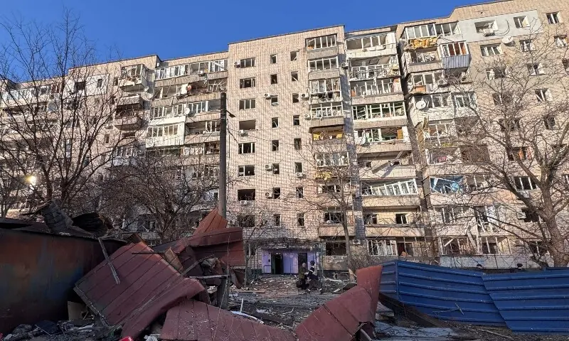A Ukrainian law enforcement officer walks amid debris in the courtyard of a damaged residential building following an air attack in Zaporizhzhia on March 14, 2026, amid the Russian invasion of Ukraine. &mdash; AFP