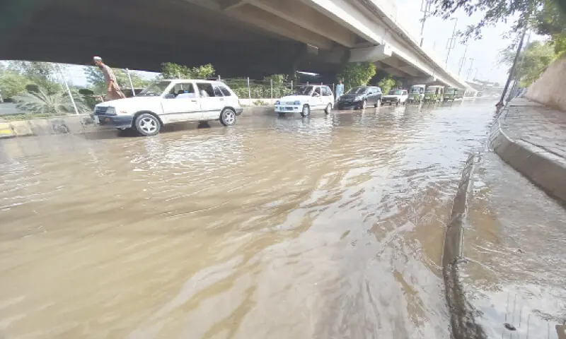 Vehicles pass through rainwater at Bacha Khan Chowk, Peshawar, on Sunday. — White Star Vehicles pass through rainwater at Bacha Khan Chowk, Peshawar, on Sunday. — White Star