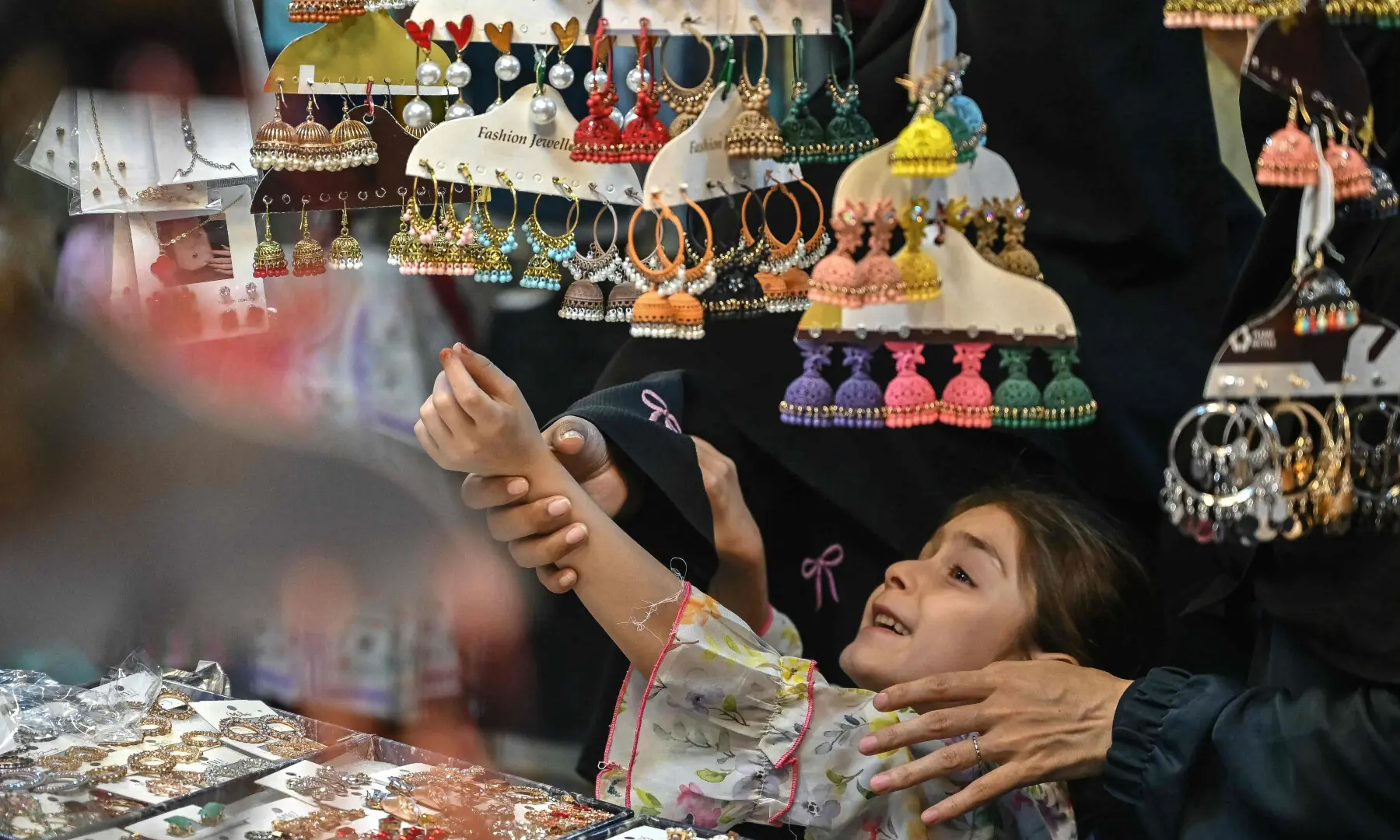 A girl shops for jewellery ahead of the Eid al-Fitr celebrations in Karachi on March 15, 2026. &mdash; AFP