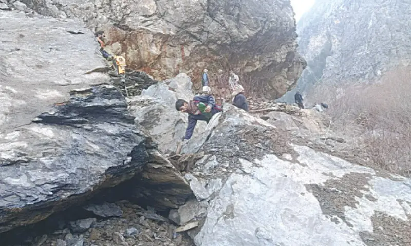 Kalash people try to cut huge boulders on self-help basis to restore vehicular traffic to Rumbur valley after a massive landslide blocked the road. &mdash; Photo by Zahiruddin