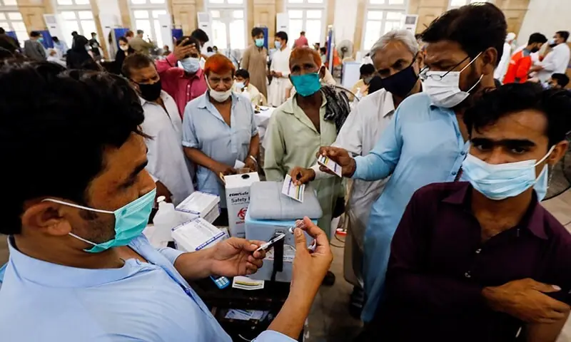 Residents with their registration cards gather at a counter to receive a dose of coronavirus vaccine at a vaccination centre in Karachi on June 9. — Reuters/File Residents with their registration cards gather at a counter to receive a dose of coronavirus vaccine at a vaccination centre in Karachi on June 9. — Reuters/File