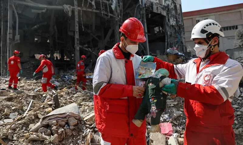 MEMBERS of a Red Crescent rescue team pick up a child&rsquo;s doll from the debris of a building that was destroyed by a US-Israeli strike in Tehran.&mdash;Reuters