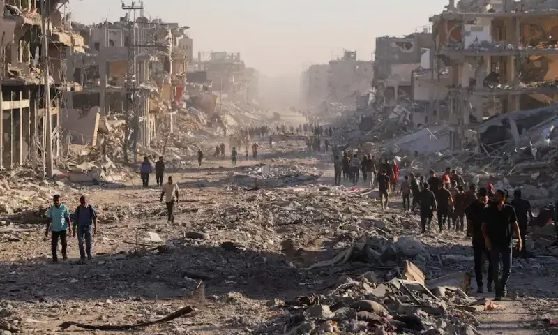 Palestinians walk through a damaged neighborhood in the aftermath of an Israeli operation, after Israel&rsquo;s government ratified a ceasefire with Hamas, in Gaza City, Oct 10. &mdash; Reuters