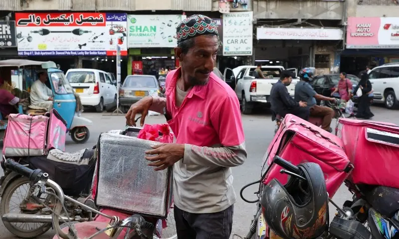 A Foodpanda delivery rider loads items into his delivery box before delivering them in Karachi, Pakistan, March 13, 2026. &mdash;Reuters