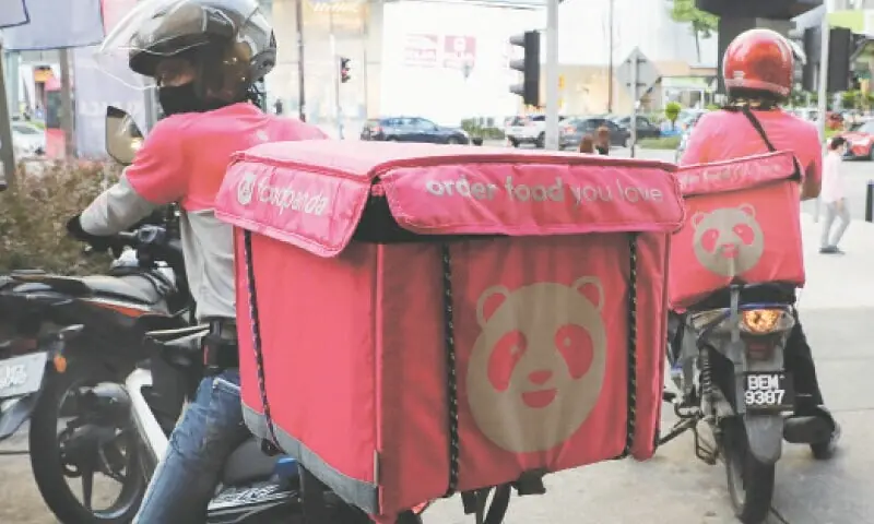 This July 8, 2020 picture shows Foodpanda riders getting ready for deliveries outside a restaurant during Covid-19 pandemic in Kuala Lumpur. &mdash;Reuters/File