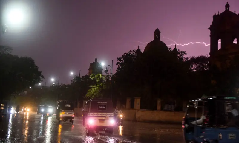 Lightning is visible as vehicles travel along a road in Karachi amid heavy rain and wind that killed 20 people and injured eight in rain-related incidents on March 18. &mdash; White Star