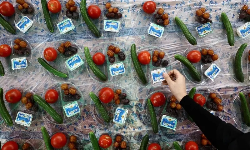 An Iranian woman prepares the iftar meal during Ramazan in a mosque, for a volunteer team that helps people clean and restore their homes after strikes, amid the US-Israeli conflict with Iran, in Tehran, Iran on March 18, 2026. &mdash; Reuters