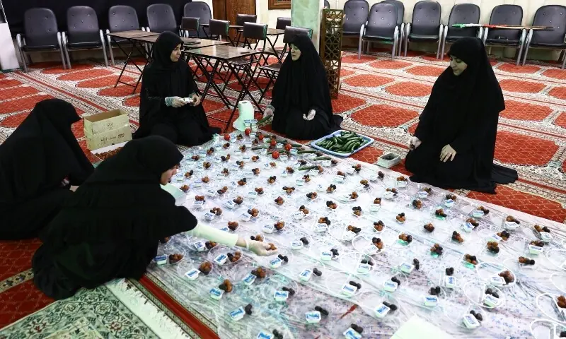 An Iranian woman prepares the iftar meal during Ramazan in a mosque, for a volunteer team that helps people clean and restore their homes after strikes, amid the US-Israeli conflict with Iran, in Tehran, Iran on March 18, 2026. &mdash; Reuters