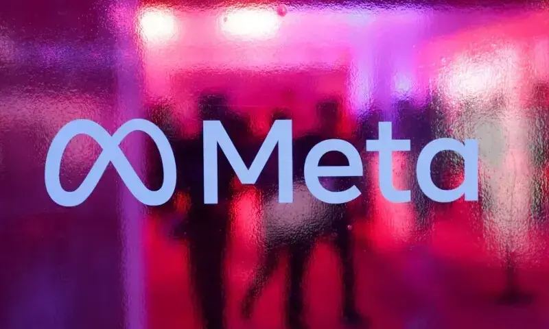 People walk behind a logo of Meta Platforms company, during a conference in Mumbai, India on September 20, 2023. &mdash; Reuters/File
