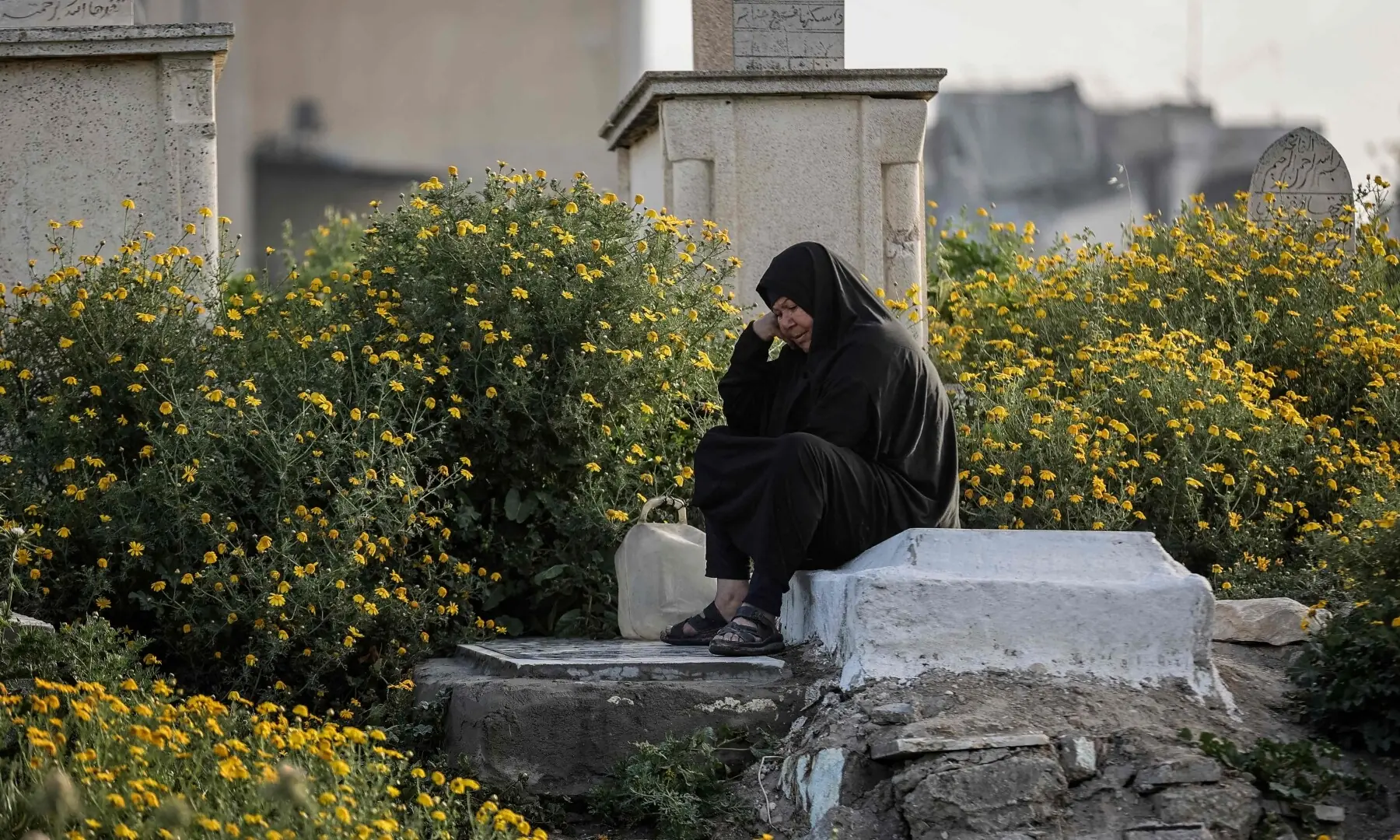 A Palestinian woman visits the grave of relatives at Al-Saraya Cemetery in Gaza City as Muslims celebrate Eidul Fitr, marking the end of Ramazan, on March 20, 2026. &mdash; AFP