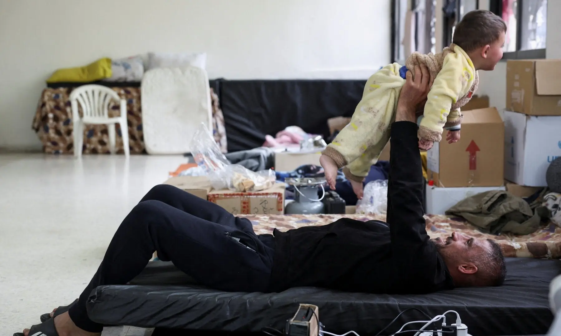 A man displaced from South Lebanon plays with a child as they take shelter in a Shia religious centre, on the day of Eid, marking the end of Ramazan, following an escalation between Hezbollah and Israel amid the US-Israeli war on Iran, in Sidon, Lebanon, March 20, 2026. &mdash; Reuters