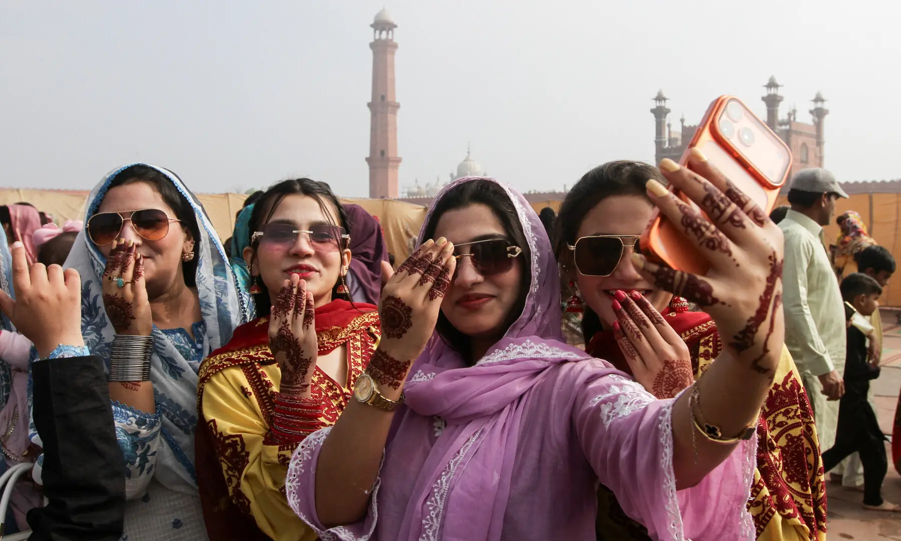 Women react as they take a selfie after attending an Eidul Fitr prayer, at the Badshahi Mosque in Lahore on March 21, 2026. &mdash; Reuters