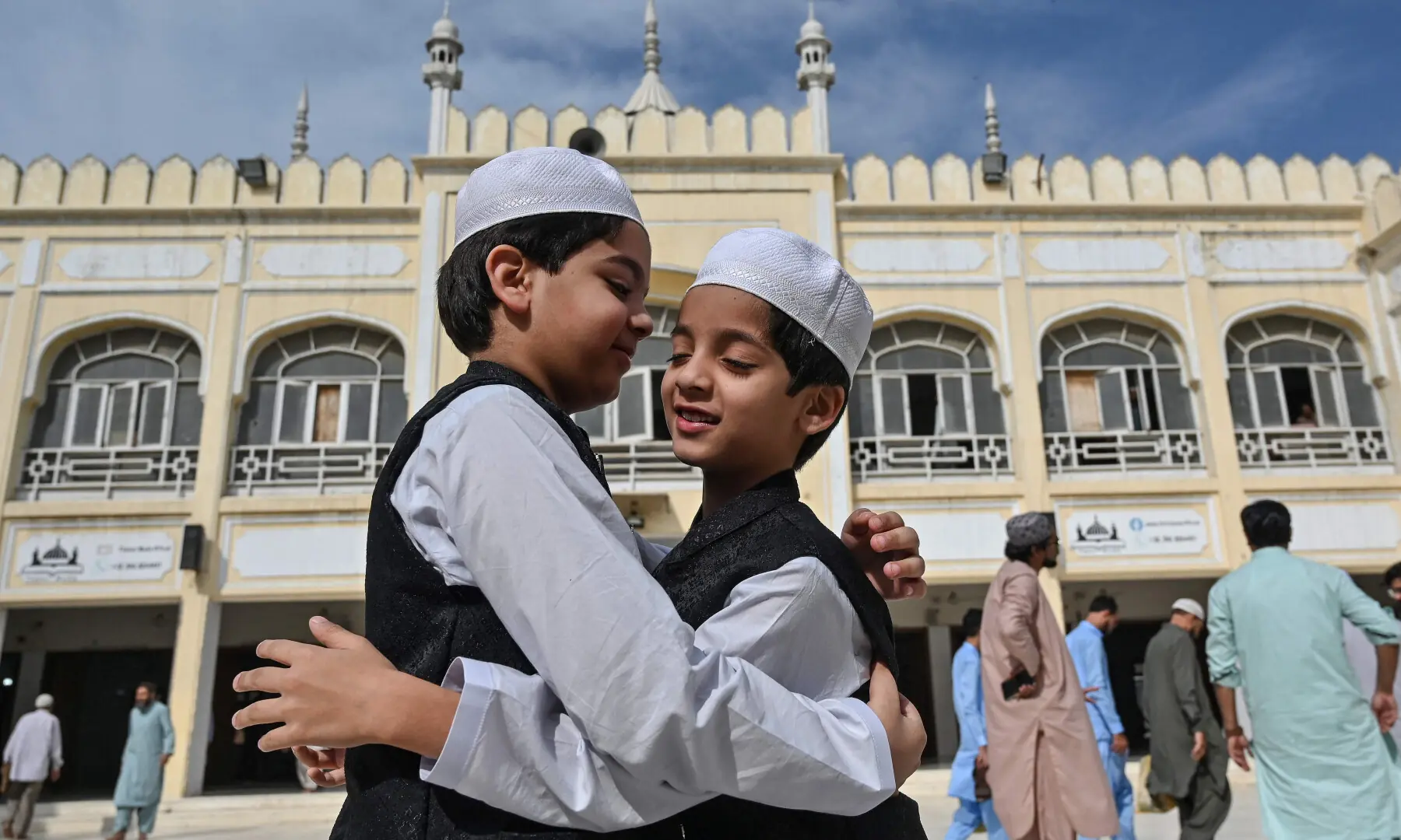 Muslim children hug each other after offering Eidul Fitr prayers, at a mosque in Karachi on March 21, 2026. &mdash; AFP