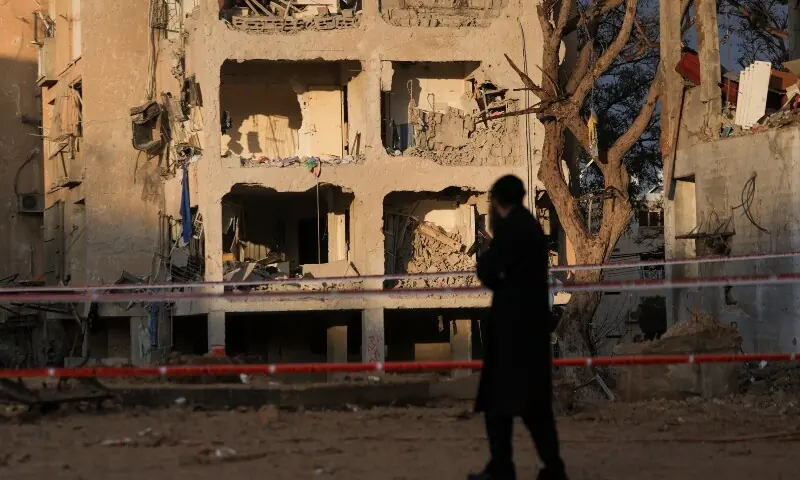 A man stands at the scene of damage after Iranian missile barrages struck residential buildings in Arad, amid the US-Israel conflict with Iran, in southern Israel, March 22. &mdash; Reuters