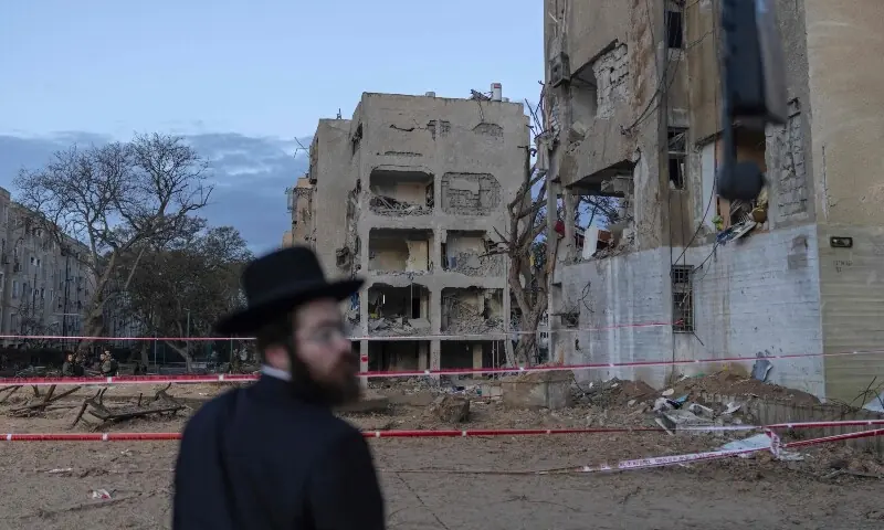 An Israeli Orthodox Jew inspects the site of an Iranian missile strike in Arad on March 22. &mdash; AFP