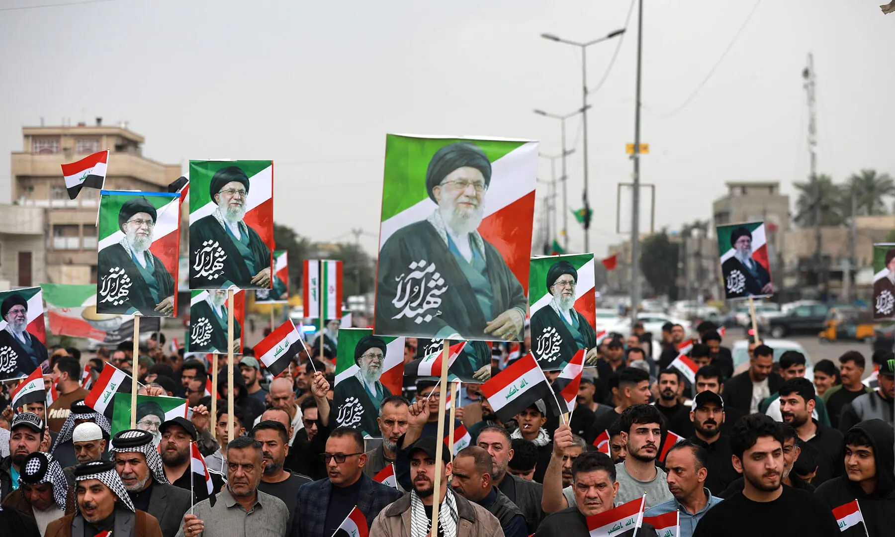 Waving the Iraqi flag and holding up placards with the image of the assassinated Iranian supreme leader Ayatollah Ali Khamenei, Iraqis rally in support of neighbouring Iran, in the al-Aamil district of Baghdad on March 22. — AFP