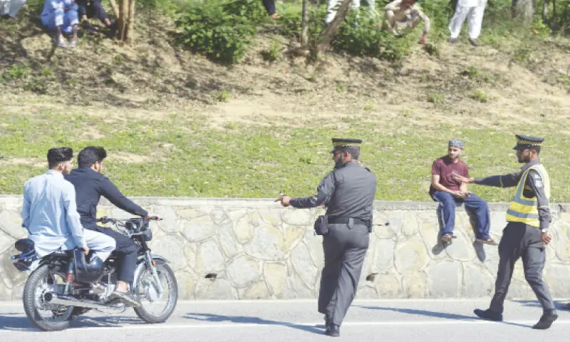 Islamabad Traffic Police officials stop a bike rider for helmet violation on the Expressway near Faizabad on Sunday. &mdash; White Star