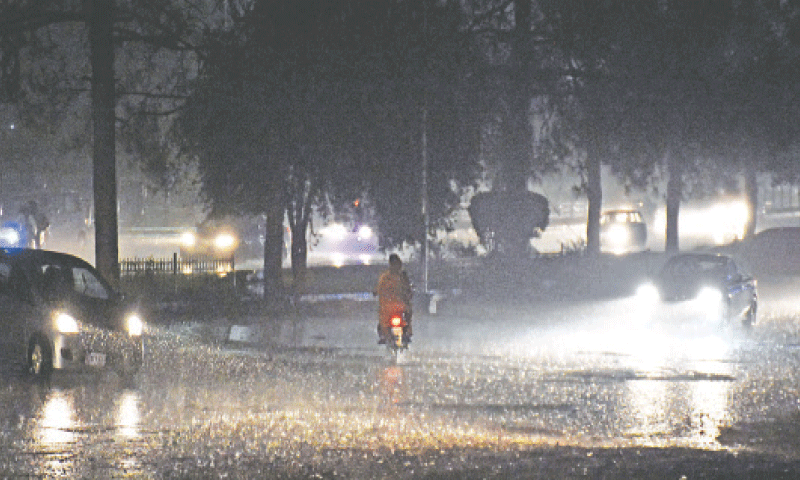 Vehicles ply during heavy rain in Islamabad. &mdash; Dawn/File
