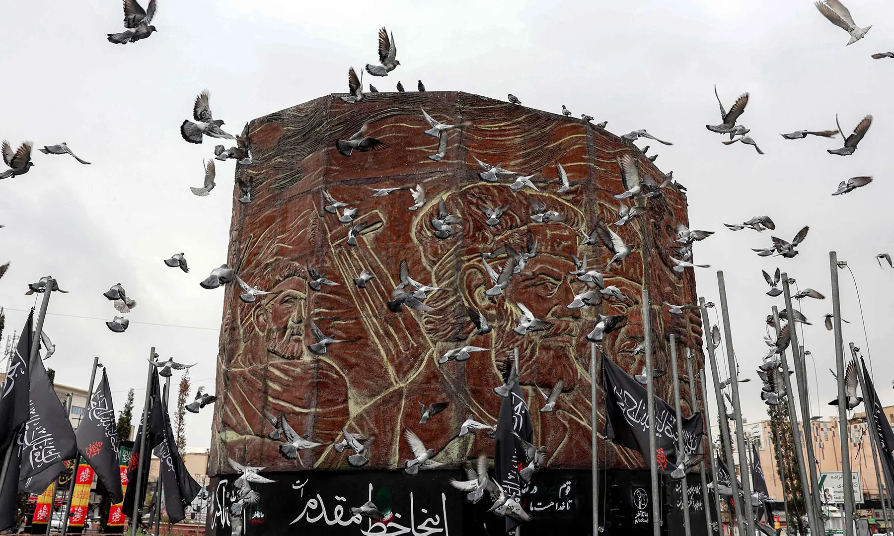 Birds fly around a monument in Enghelab Square in central Tehran, Iran on March 25.. &mdash; AFP