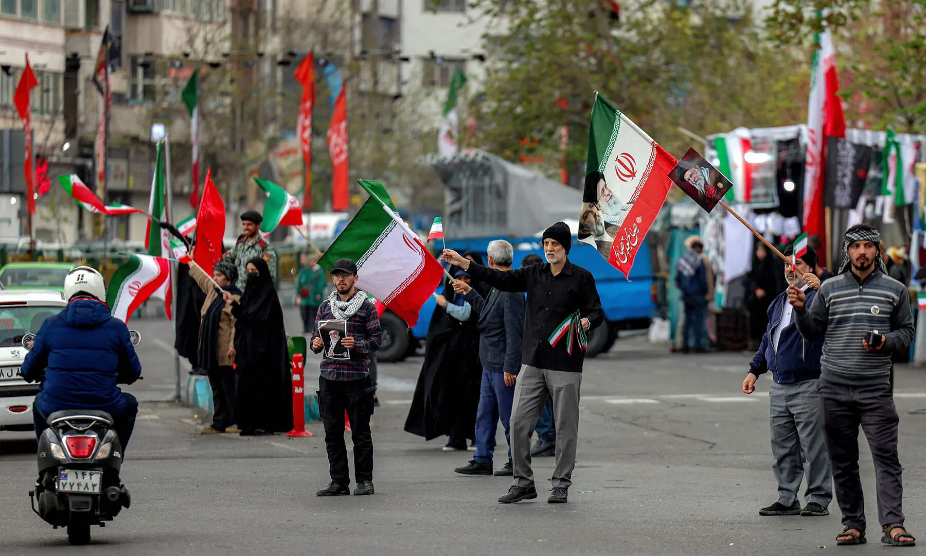 People gather with Iranian flags in Enghelab Square in central Tehran, Iran on March 25. &mdash; AFP