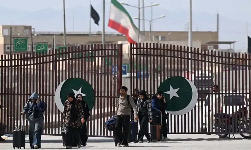 Pakistanis walk across the Taftan border as they return from Iran amid ongoing US-Israel strikes on Tehran.&mdash;AFP/File