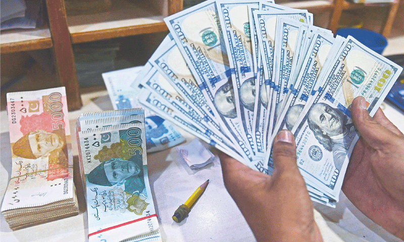 A file photo of hands counting Pakistani and US banknotes. &mdash; AFP/File