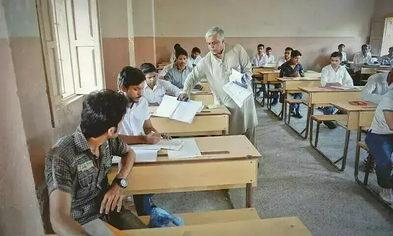 Invigilator hands exam paper to students. — Dawn/File Invigilator hands exam paper to students. — Dawn/File