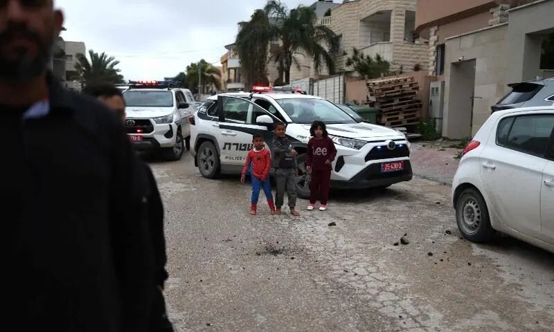 Children look on following a projectile strike in the Arab-Israeli city of Kfar Qassem on March 26, 2026. &mdash;AFP