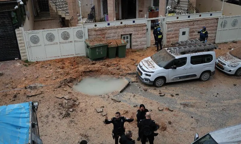 Israeli rescuers and security personnel survey the site struck by a projectile in the Arab-Israeli city of Kfar Qassem on March 26, 2026. &mdash;AFP