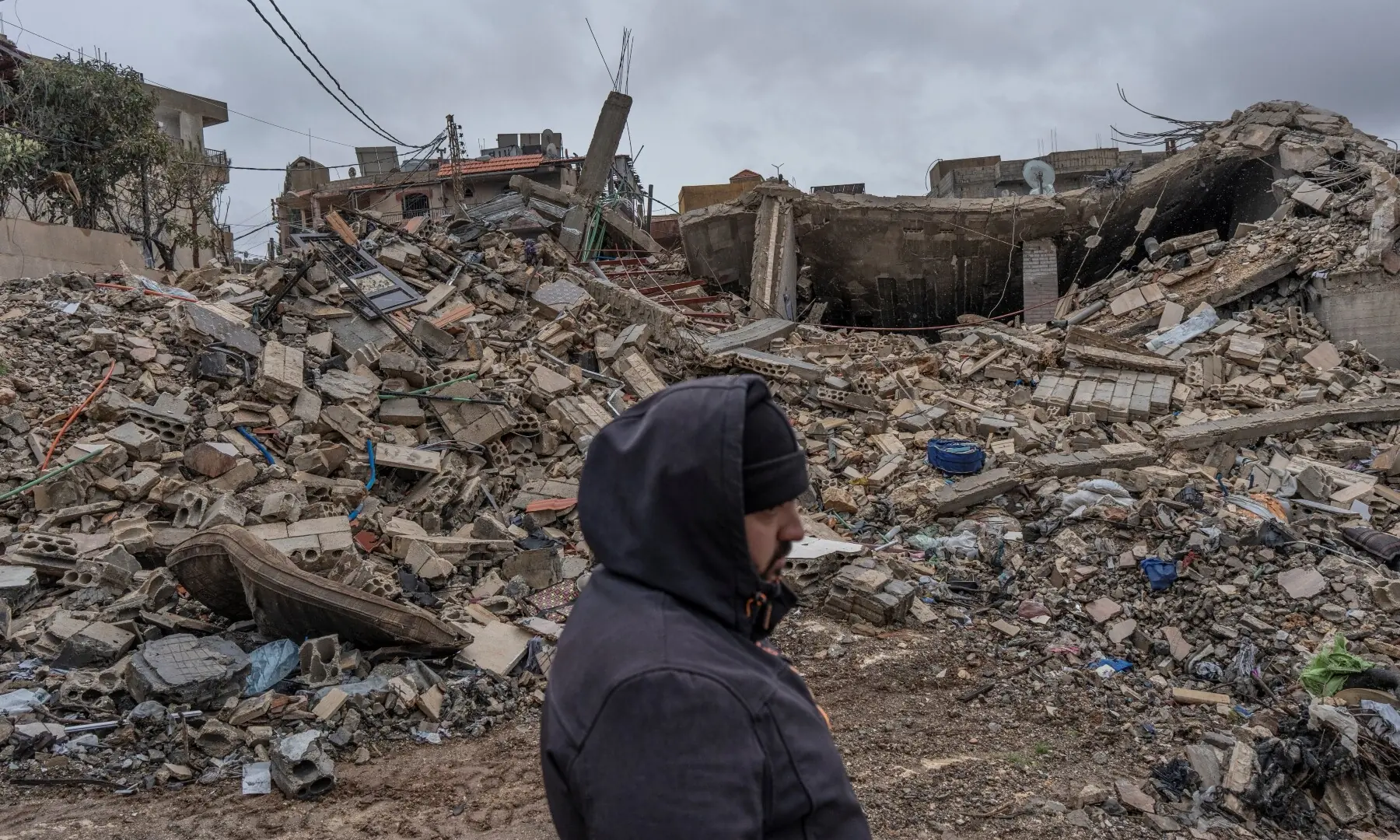A local walks past a building destroyed by Israeli strikes, amid escalating hostilities between Israel and Hezbollah, as the US-Israeli conflict with Iran continues, in Nabi Chit, Lebanon on March 26. &mdash; Reuters