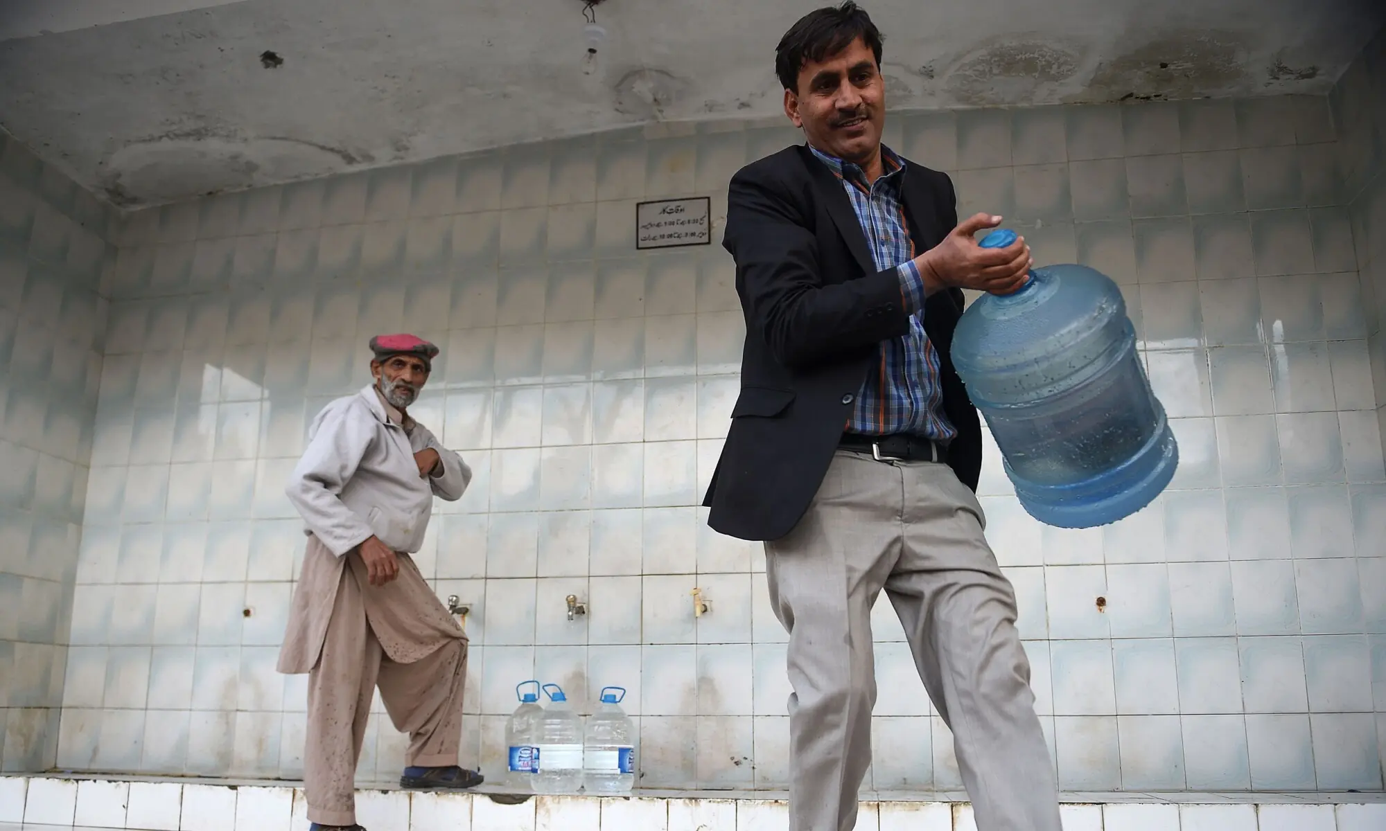 A man carrying a bottle at a water filtration plant in Islamabad. — AFP/File A man carrying a bottle at a water filtration plant in Islamabad. — AFP/File