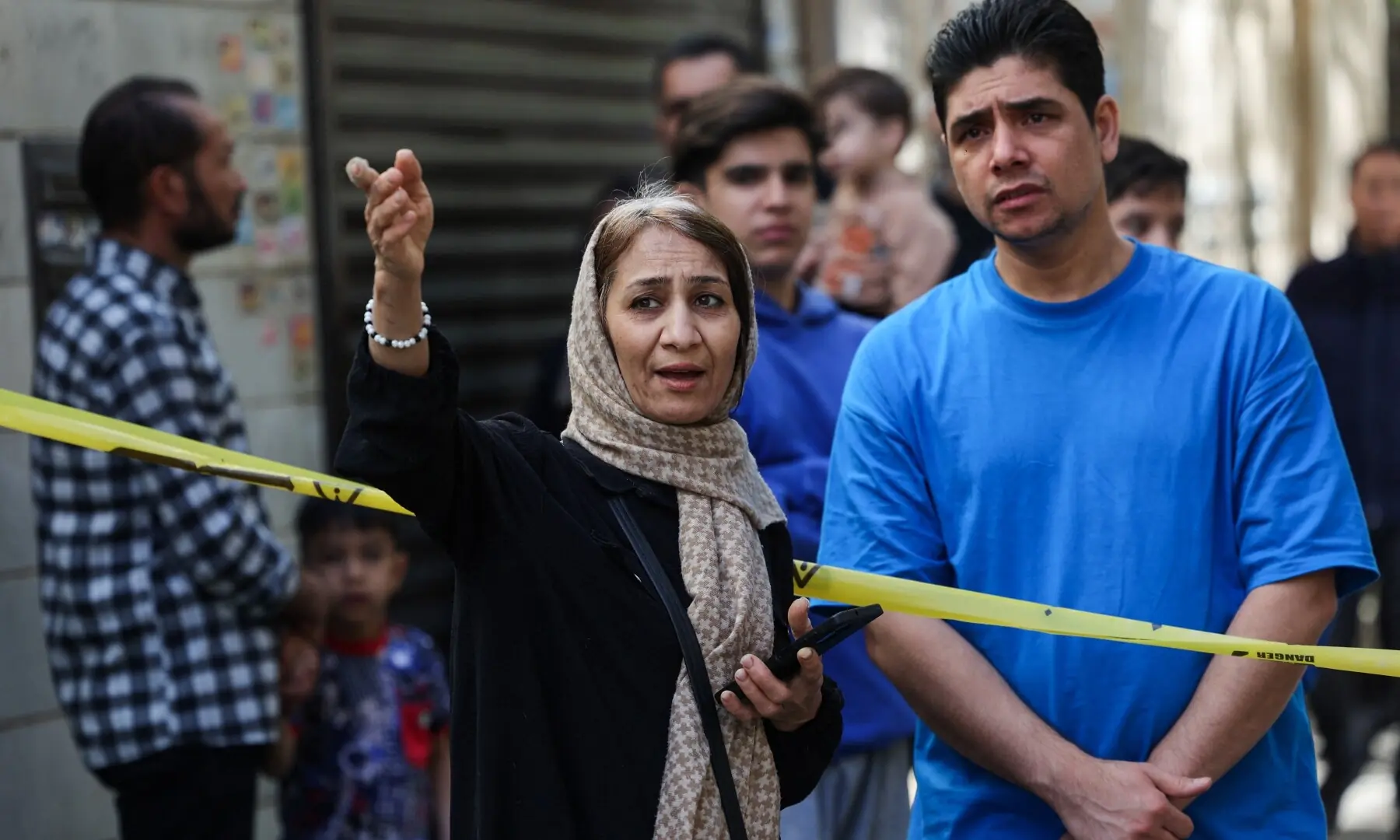 People gather by a cordon tape at the site of a residential building damaged by a strike, amid the US-Israeli war on Iran, in Tehran, Iran on March 27, 2026. — Reuters