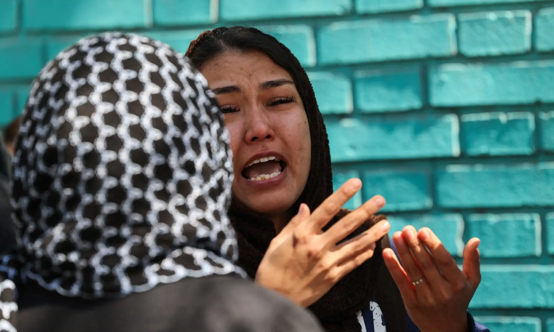 A woman reacts next to the site of a residential building damaged by a strike, amid the US-Israeli war on Iran, in Tehran, Iran on March 27, 2026. &mdash; Reuters