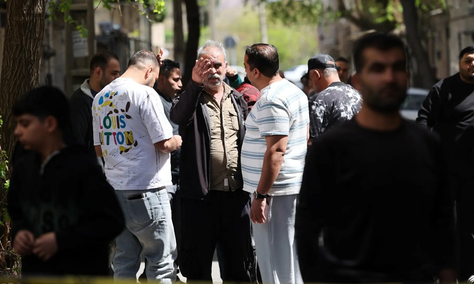 People gather by a cordon tape at the site of a residential building damaged by a strike, amid the US-Israeli war on Iran, in Tehran, Iran on March 27, 2026. — Reuters