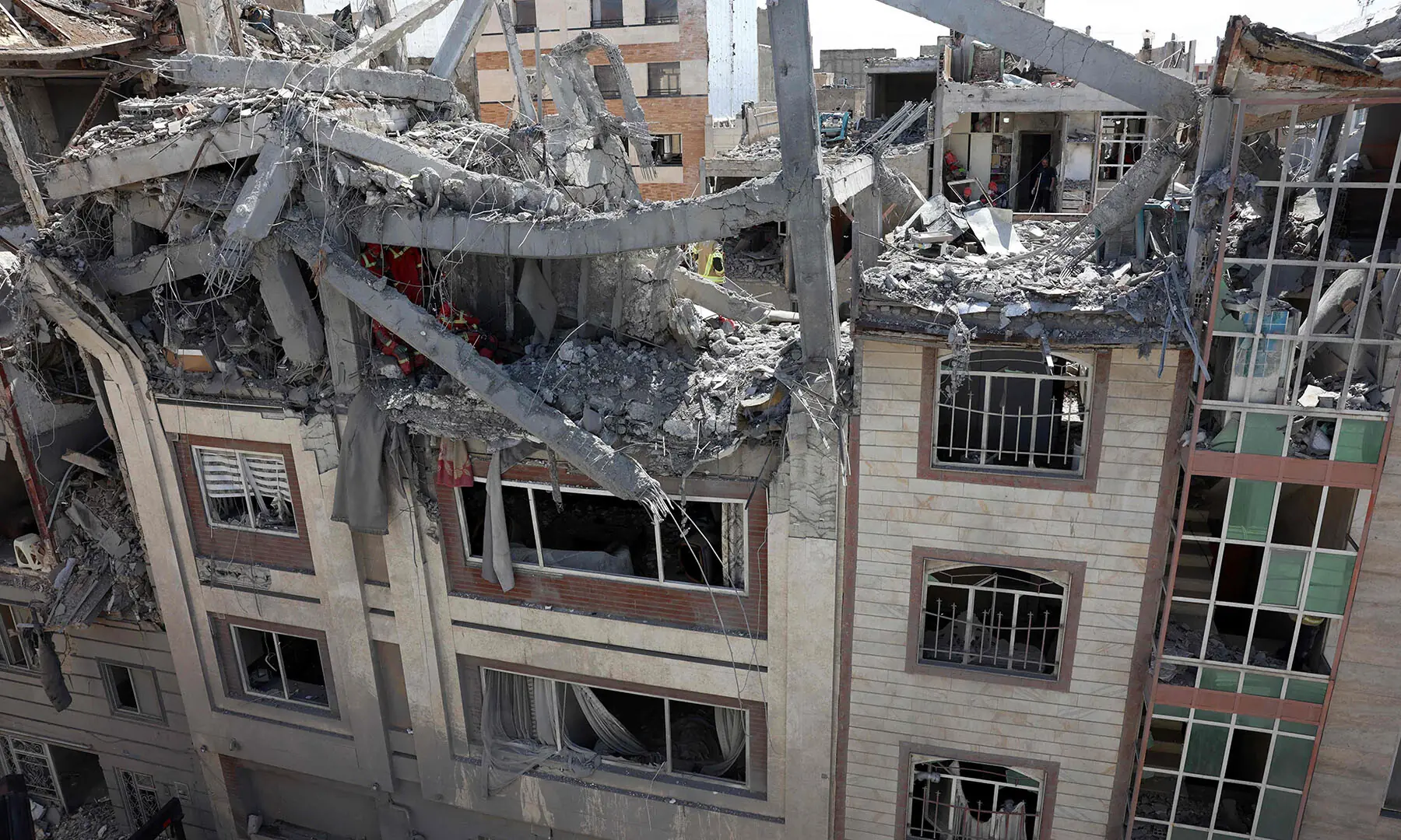 Firefighters look for victims and inspect damages at a residential building in southern Tehran, Iran on March 27. &mdash; AFP