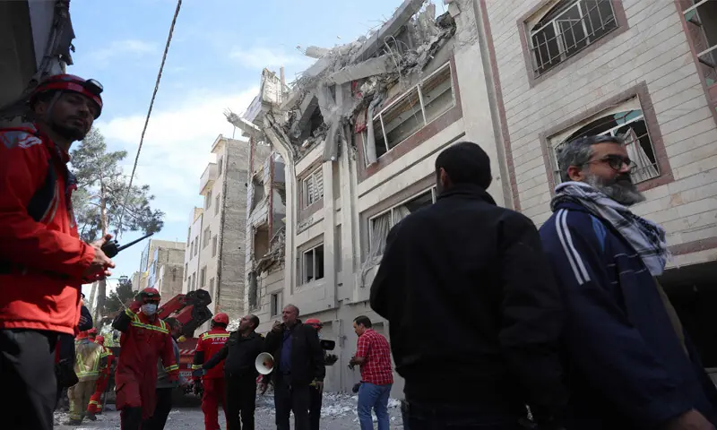TEHRAN: Firefighters and rescue workers look for victims at a residential building, which was targeted by US-Israeli air strikes.—AFP TEHRAN: Firefighters and rescue workers look for victims at a residential building, which was targeted by US-Israeli air strikes.—AFP