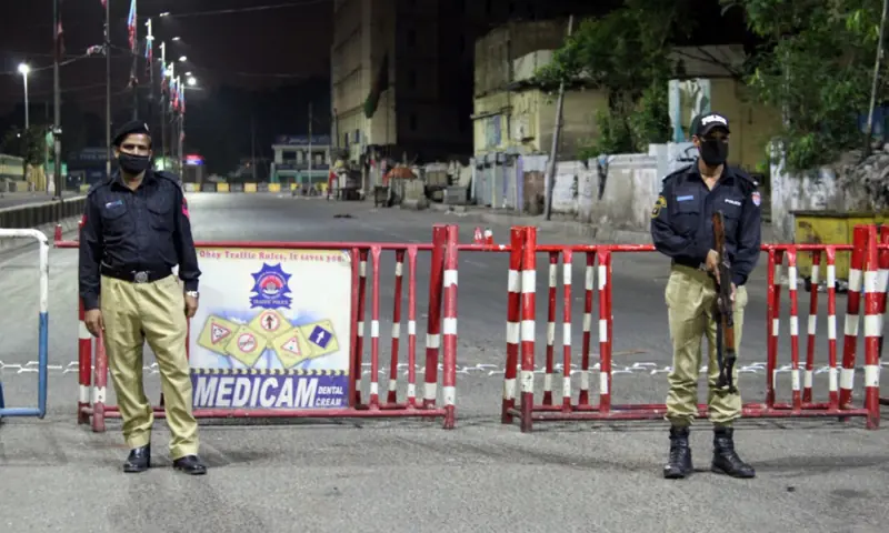 Policemen stand at a blocked road in Karachi. — Photo by Shahzeb Ahmed/File Policemen stand at a blocked road in Karachi. — Photo by Shahzeb Ahmed/File