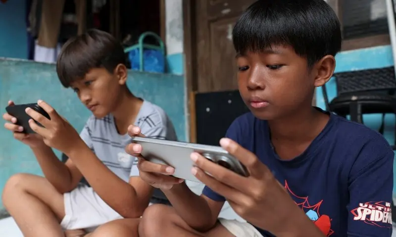 Affan Haritsah, 11 and Kevin Prince, 14, play games on their phones, as Indonesia’s communications and digital information ministry implements restrictions against “high-risk” social media platforms, including Facebook, TikTok, and Roblox, in Depok, on the outskirts of Jakarta, Indonesia, March 28, 2026. —Reuters Affan Haritsah, 11 and Kevin Prince, 14, play games on their phones, as Indonesia’s communications and digital information ministry implements restrictions against “high-risk” social media platforms, including Facebook, TikTok, and Roblox, in Depok, on the outskirts of Jakarta, Indonesia, March 28, 2026. —Reuters
